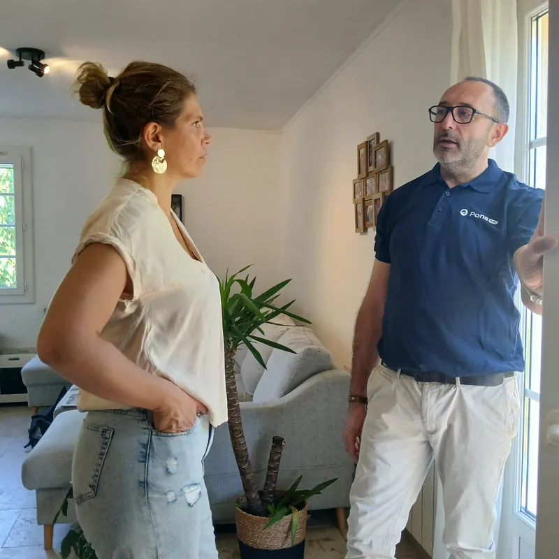 Guillaume Pons échange avec une propriétaire dans son séjour