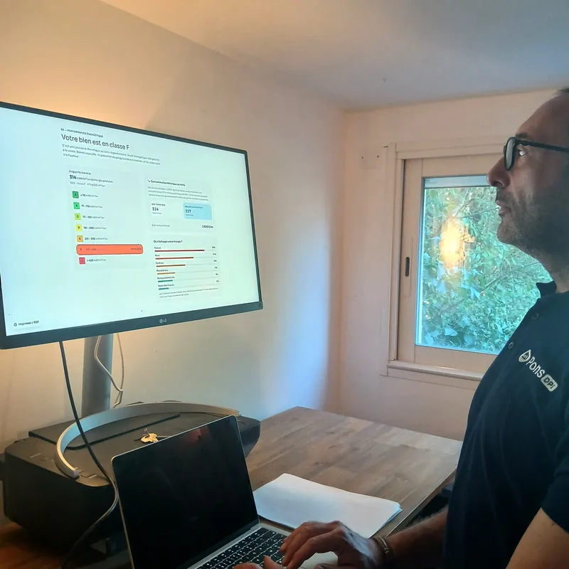 Guillaume Pons devant un grand écran affichant la page « Votre bien est en classe F » du rapport interactif