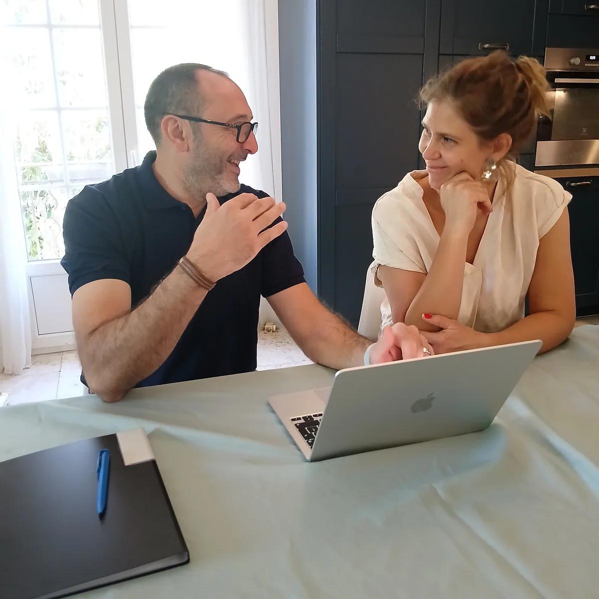 Guillaume Pons explique un point du rapport à une propriétaire souriante, à table
