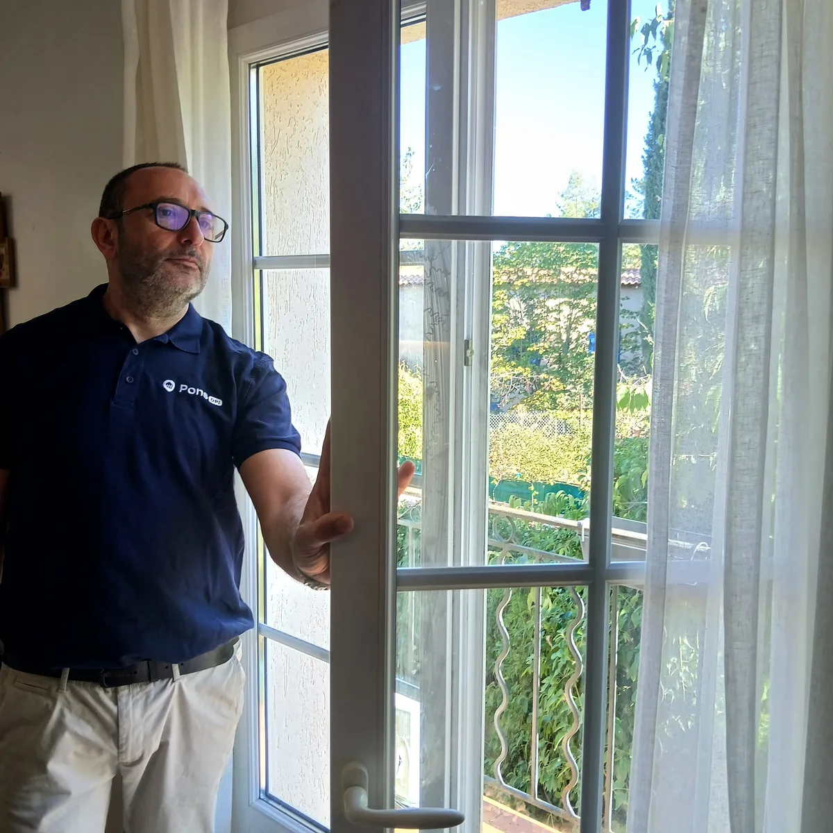 Guillaume Pons ouvre une porte-fenêtre donnant sur le jardin