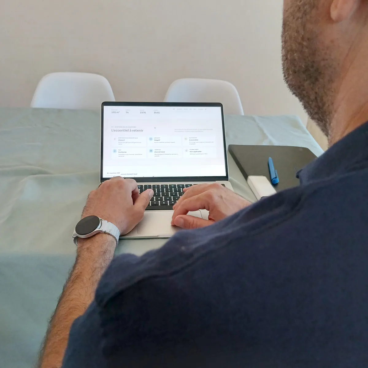 Guillaume Pons, de dos, consulte un rapport sur son ordinateur portable